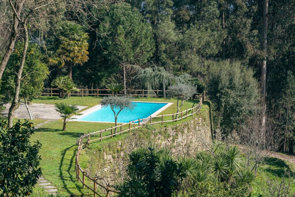 Piscina e jardim da quinta do Banduja Reserve, entre árvores