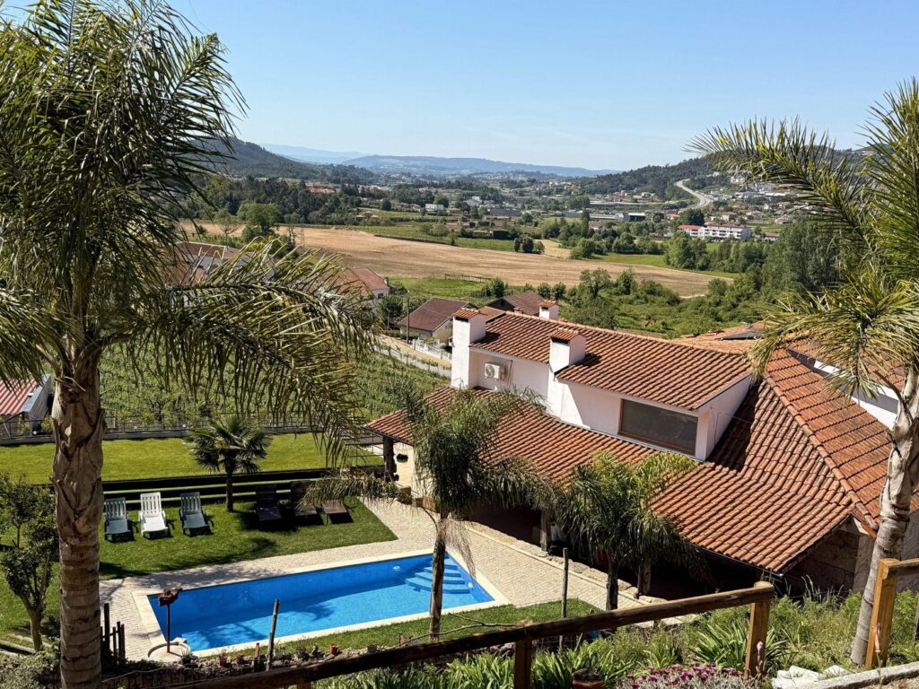 Piscina e jardim vistos do alto, com o vale ao fundo
