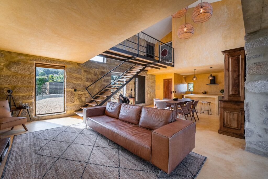 Sala da Villa com escada de ferro e paredes de pedra